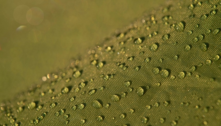 Water droplets on waterproof fabric.Water drops on a green waterproof fabric close-up macro photography.Water drops on a waterproof fabric. ( Water droplets on the tent fabric.)	