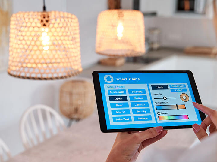 Rear view of woman using an app on a tablet to control the lighting in her home