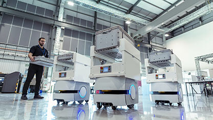 Worker with factory storage robots in warehouse storage research factory