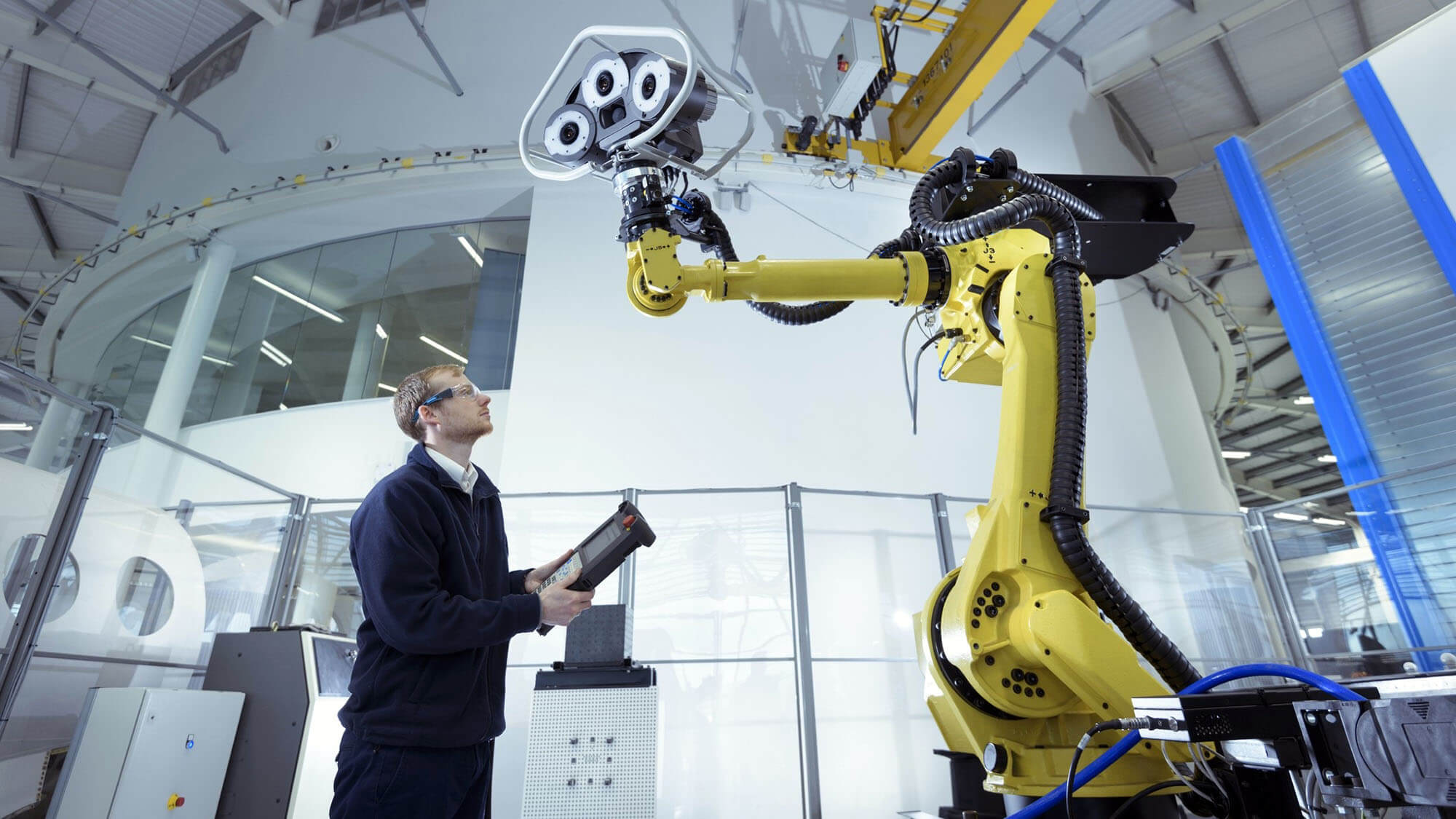 Engineer with robot in robotics research facility, low angle view